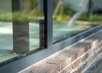 foto van een Le Bocq aluminium kozijn in een nieuwbouwwoning in aanbouw. Je ziet dat het glas er al in zit. De details van het alumnium kozijn in de hoek zijn goed zichtbaar.